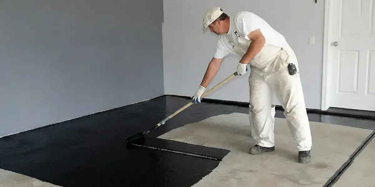 basement waterproofing professional applying waterproof coating to protect a basement floor in West Palm Beach, FL