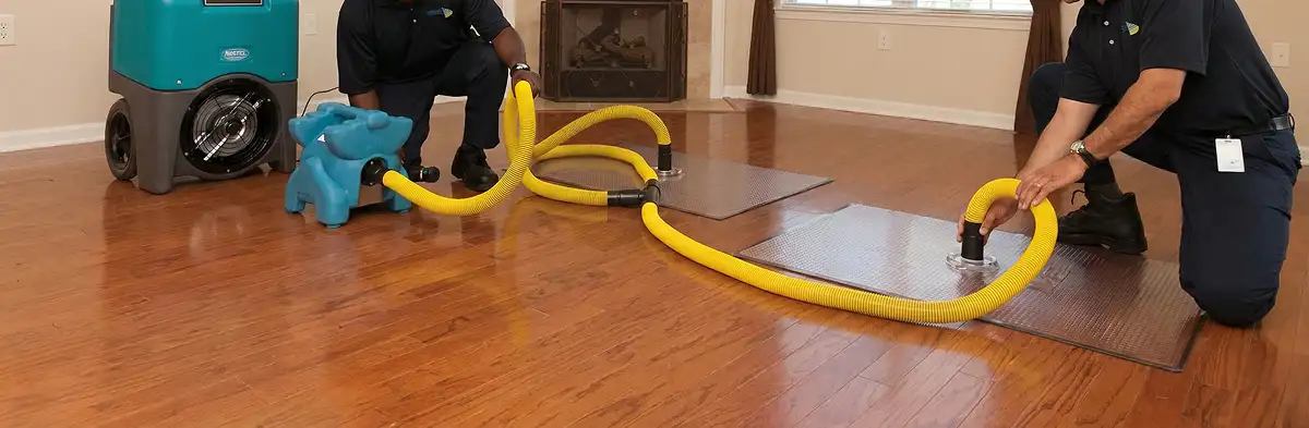 emergency water removal technicians extracting standing water from a home using professional equipment in West Palm Beach, FL
